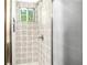 Detailed view of a tiled shower with a glass door and natural light from a window at 220 Hillswick Ct, Atlanta, GA 30328