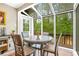 Charming sunroom dining area surrounded by large windows overlooking the deck and lush backyard at 220 Hillswick Ct, Atlanta, GA 30328