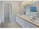 Bathroom with double sink vanity, large mirror, and window above at 30 Trelawney Ct, Covington, GA 30016
