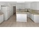 Functional kitchen featuring white cabinets, an island, and tiled floors at 30 Trelawney Ct, Covington, GA 30016
