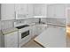 Well-lit kitchen featuring white appliances and ample counter space at 30 Trelawney Ct, Covington, GA 30016