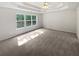 Main bedroom featuring a tray ceiling, carpet, and large windows at 30 Trelawney Ct, Covington, GA 30016
