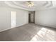 Spacious main bedroom with tray ceiling, fan, and carpet at 30 Trelawney Ct, Covington, GA 30016