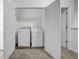 Laundry room with white washer and dryer, and storage rack at 3037 Bonnes Dr, Lithonia, GA 30038