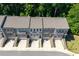 Aerial view of brick townhomes with private entrances and attached garages, surrounded by lush greenery at 3982 Carver Cir, Doraville, GA 30360
