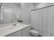 Neutral bathroom with a white vanity, a large mirror, and a white shower curtain, blending functionality and design at 3982 Carver Cir, Doraville, GA 30360