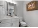 Stylish half bathroom with a modern vanity, framed mirror, and neutral decor at 3982 Carver Cir, Doraville, GA 30360