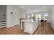 Bright, open kitchen featuring an island with seating, stainless steel appliances, white cabinets, and hardwood floors at 3982 Carver Cir, Doraville, GA 30360