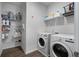 Functional laundry room with modern washer and dryer, shelving, and ample storage for laundry essentials at 3982 Carver Cir, Doraville, GA 30360