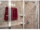 Glass-enclosed shower with tile walls and multiple shelves for storage at 4306 Laurel Creek Se Ct, Smyrna, GA 30080