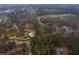 An aerial view showing a park with an amphitheater, a green athletic field, parking areas, and surrounding buildings and trees at 4649 Equestrian Way, Atlanta, GA 30338