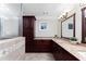 Bathroom featuring double sinks, granite counters, dark cabinets, and glass enclosed shower at 4649 Equestrian Way, Atlanta, GA 30338