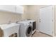 Practical laundry room features a utility sink, modern washer and dryer, white cabinets, and access door at 4649 Equestrian Way, Atlanta, GA 30338