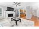 Open concept living room with fireplace, ceiling fan and view into the kitchen at 4649 Equestrian Way, Atlanta, GA 30338
