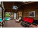 Inviting sunroom featuring skylights, wood-paneled walls, and a cozy seating area with a red couch, perfect for relaxation at 4649 Equestrian Way, Atlanta, GA 30338