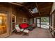 Relaxing sunroom with skylights, wood paneling, and comfortable seating, including a red couch and wicker furniture at 4649 Equestrian Way, Atlanta, GA 30338