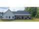 Rear view of white home with covered patio and fenced yard with trees at 62 Presley Farm Pkwy, Rockmart, GA 30153