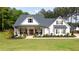 Charming white farmhouse with a welcoming front porch, dark shutters, and lush green lawn at 62 Presley Farm Pkwy, Rockmart, GA 30153