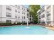 Outdoor pool surrounded by a wrought iron fence, green landscaping, and a modern building at 821 Ralph Mcgill Ne Blvd # 2113, Atlanta, GA 30306