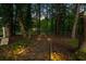 A serene backyard path with solar lights leads to a lake behind this beautiful home and property at 2334 Fisher Dr, Loganville, GA 30052