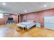 Finished basement bedroom featuring brick accent wall and light grey furniture at 2334 Fisher Dr, Loganville, GA 30052