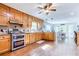 Open kitchen with stainless steel appliances, wood cabinets, hardwood floors, and adjacent dining area at 2334 Fisher Dr, Loganville, GA 30052