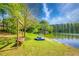 Scenic lakefront with a bench swing, paddle boat, and lush greenery at 2334 Fisher Dr, Loganville, GA 30052