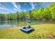 Relaxing lakefront view with a paddle boat on the grassy bank and green trees at 2334 Fisher Dr, Loganville, GA 30052