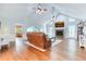 Spacious living room with vaulted ceiling, fireplace, hardwood floors, and an open design leading to kitchen at 2334 Fisher Dr, Loganville, GA 30052