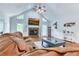 Vaulted living room featuring a stone fireplace, hardwood flooring, and ample natural light from many windows at 2334 Fisher Dr, Loganville, GA 30052