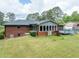 Large backyard features a well-kept lawn, brick house, an exterior deck, and easy access to the basement at 3089 Ranlo Dr, Atlanta, GA 30340