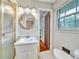 Bathroom with a vanity sink, round mirror, and a shower with gold trim at 3089 Ranlo Dr, Atlanta, GA 30340