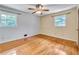 Bright bedroom featuring hardwood floors, two windows, and a ceiling fan with lighting at 3089 Ranlo Dr, Atlanta, GA 30340