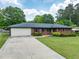 Traditional brick home showcases a well-kept lawn, long driveway, and attached two-car garage at 3089 Ranlo Dr, Atlanta, GA 30340