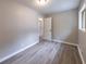Bedroom offers light gray color scheme, wood-look floors, window, and view to another room at 493 Woods Nw Dr, Atlanta, GA 30318