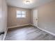 Empty bedroom with neutral walls, luxury vinyl plank floors, a window, and white trim at 493 Woods Nw Dr, Atlanta, GA 30318