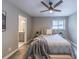 Bedroom with ceiling fan, bed with decorative pillows, view to bathroom, and wood-look floors at 493 Woods Nw Dr, Atlanta, GA 30318
