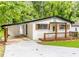 This home offers a inviting front porch, carport, and newly painted white brick at 493 Woods Nw Dr, Atlanta, GA 30318