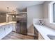 Updated kitchen with stainless steel refrigerator, white countertops and cabinets, subway tile backsplash and modern lighting at 493 Woods Nw Dr, Atlanta, GA 30318