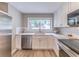 Updated kitchen with white cabinets, stainless steel appliances and sink, granite counters, and subway tile backsplash at 493 Woods Nw Dr, Atlanta, GA 30318