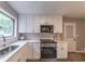 Renovated kitchen featuring white cabinets, stainless steel oven and microwave, stone countertops, and subway tile backsplash at 493 Woods Nw Dr, Atlanta, GA 30318