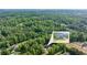 Aerial shot with an inset showcasing a beautiful home surrounded by lush greenery and neighboring houses at 5652 Burruss Rd, Cumming, GA 30028