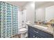 Bathroom features a blue vanity with granite countertop and a shower with a colorful curtain at 5652 Burruss Rd, Cumming, GA 30028