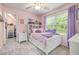 Cozy bedroom features pink walls, a window, ceiling fan, and white furniture at 5652 Burruss Rd, Cumming, GA 30028
