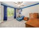 Bright bedroom features a window, ceiling fan, gray carpet, and a blue accent wall at 5652 Burruss Rd, Cumming, GA 30028