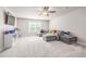 Large bonus room with a gray sectional, carpet, and lots of natural light at 5652 Burruss Rd, Cumming, GA 30028