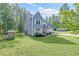 Side view of a charming home surrounded by green grass and a lush tree line at 5652 Burruss Rd, Cumming, GA 30028