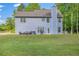 Two-story home with a well-kept lawn, featuring an outdoor patio, backyard, and mature trees at 5652 Burruss Rd, Cumming, GA 30028