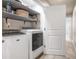 Bright laundry room with modern washer and dryer, open shelving, and a conveniently placed doorway at 5652 Burruss Rd, Cumming, GA 30028