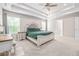Bright main bedroom offers a tray ceiling, carpet, and a comfortable bed at 5652 Burruss Rd, Cumming, GA 30028